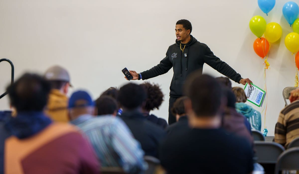 Derrick Moore speaking to a room in Alaska
